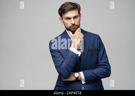 Studuo shot of thinking businessman wearing suit Stock Photo