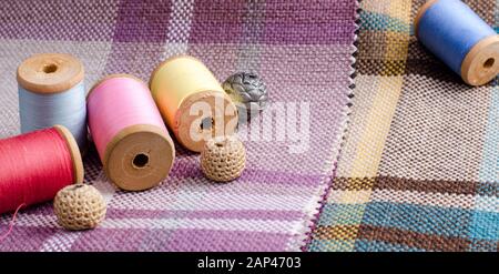 sewing supplies, needles, scissors on the colorful gunny textile background. Photo in gentle pastel colors Stock Photo