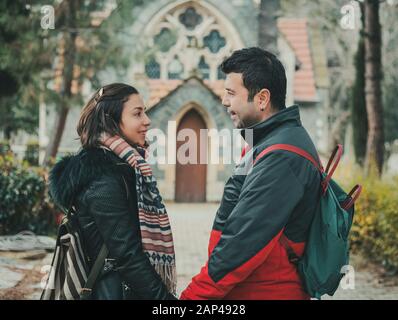 Young couple looking to each other and smiling while holding their hands Stock Photo