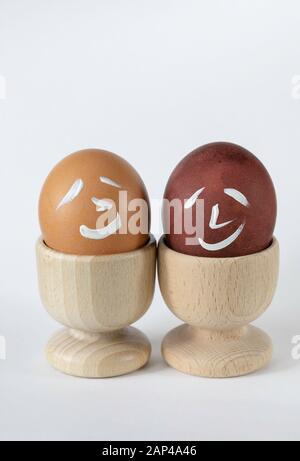 Painted and raw eggs. Funny drawings on eggshells. Easter artistic decoration. Stock Photo