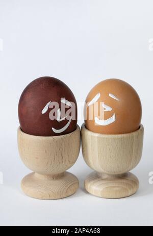 Painted and raw eggs. Funny drawings on eggshells. Easter artistic decoration. Stock Photo