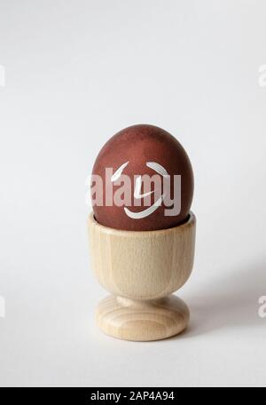 Painted and raw eggs. Funny drawings on eggshells. Easter artistic decoration. Stock Photo