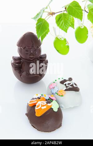 Chocolate chicken and homemade cake baked with cream decoration on an Easter tea table. Easter wallpaper Stock Photo