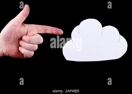 In the cloud computing concept with hand pointing to a cloud cardboard cutout Stock Photo