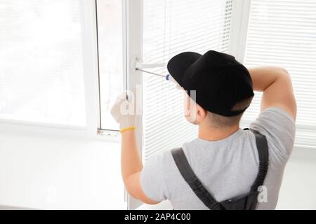 Construction worker man install plastic white upvc windows in house Stock Photo