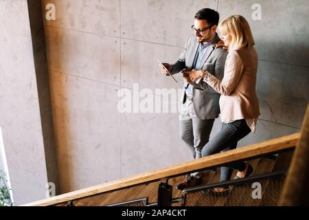 Cheerful coworkers in office working and brainstorming together Stock Photo