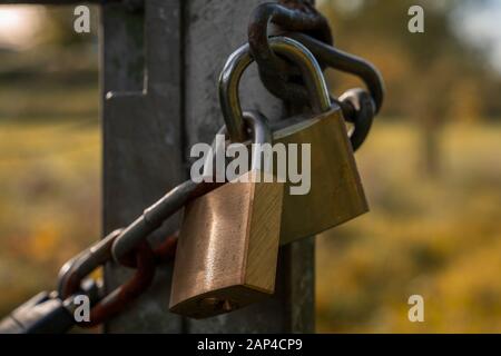 An iron chain with two padlocks on a gate Stock Photo