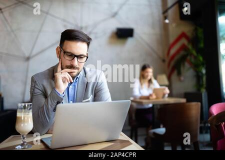 Happy confident businessman working, using laptop in office Stock Photo