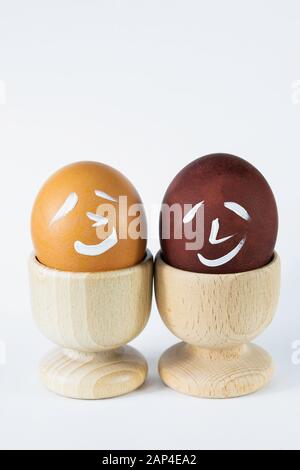Painted and raw eggs. Funny drawings on eggshells. Easter artistic decoration. Stock Photo