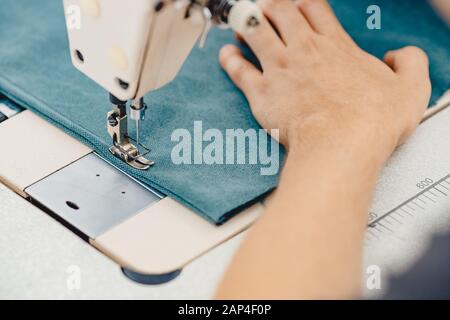 Male hands tailor working on sewing machine, making shopper bag from fabric Stock Photo