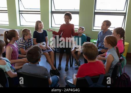 Group of elementary school kids sitting in a circle Stock Photo