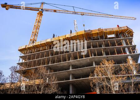 Multi-level concrete building under construction with tower crane; new residential development in the heart of Silicon Valley, San Jose, California Stock Photo