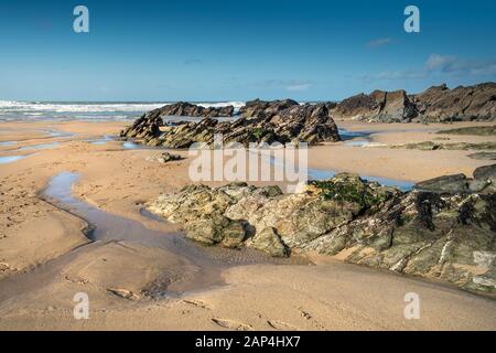 Rocks exposed at low tide on Fistral Beach in Newquay in Cornwall. Stock Photo