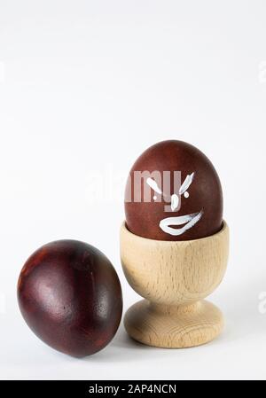 Painted and raw eggs. Funny drawings on eggshells. Easter artistic decoration. Stock Photo