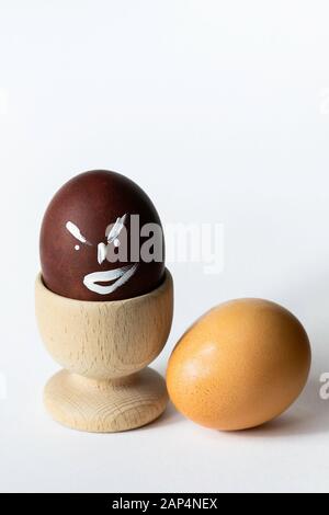 Painted and raw eggs. Funny drawings on eggshells. Easter artistic decoration. Stock Photo