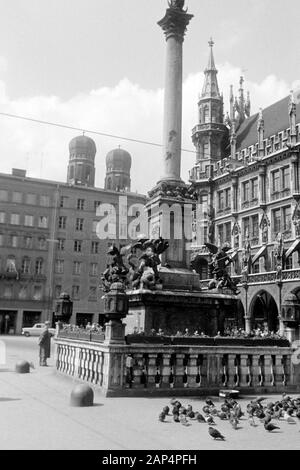 Blick auf den Sockel der Mariensäule am Marienplatz, im Hintergrund die Türme der Frauenkirche, rechts das Neue Rathaus, 1957. View of the Marian column's base on Mary's Square with the Frauenkirche steeples in the background, the New Town Hall on the right side,1957. Stock Photo