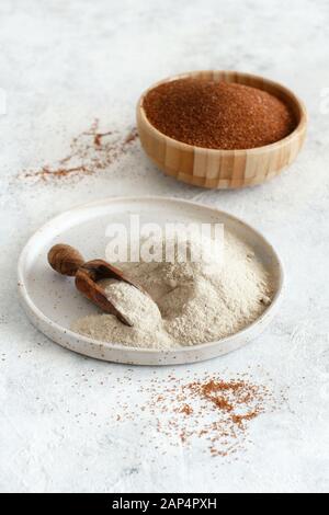 Teff flour on a plate with a spoon and teff grain in a bowl  close up Stock Photo