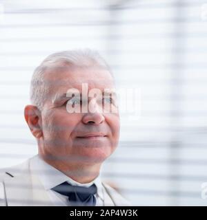 close up. pensive businessman looking through window blinds Stock Photo