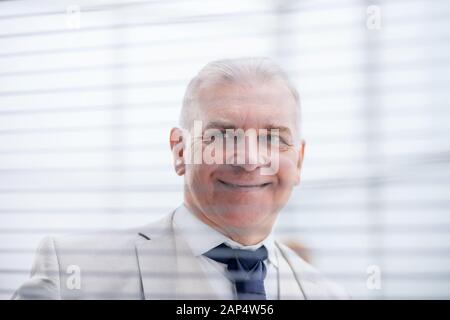close up. pensive businessman looking through window blinds Stock Photo