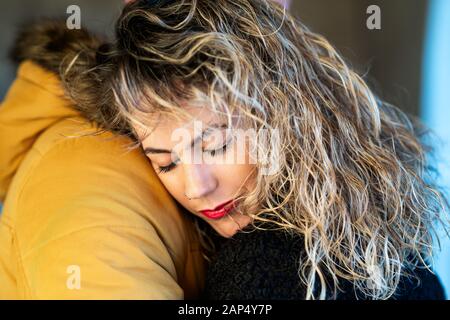 Portrait of a lovely woman with close eyes  hugging her man. Stock Photo