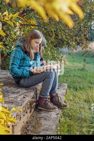 Teenage girl and boy reading books outdoors Stock Photo