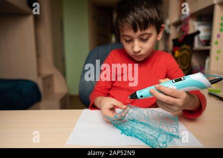 Boy creating volume plastic figure with 3D pen. Selective focus. Education concept Stock Photo