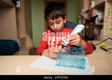 Boy creating volume plastic figure with 3D pen. Selective focus. Education concept Stock Photo