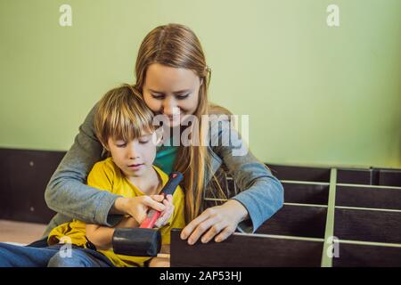 Mother and son assembling furniture. Boy helping his mom at home. Happy Family concept Stock Photo