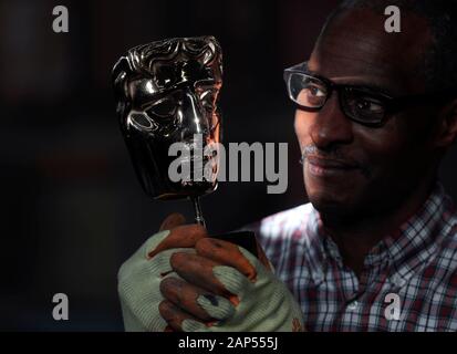 Embargoed to 0001 Wednesday January 22. Moulder Rupert Francis looks at a finished mask during the casting of the British Academy of Film and Television Awards (BAFTA) masks at a foundry in West Drayton, west London, ahead of the ceremony on February 2. Stock Photo