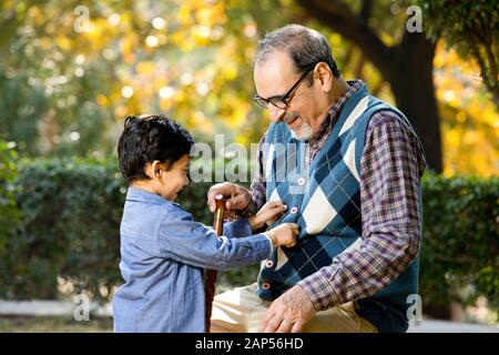 Loving grandfather playing with his grandson at park Stock Photo