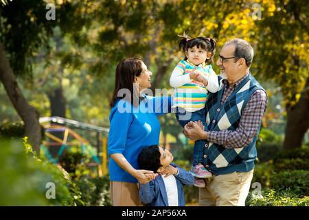 Happy grandparents spending leisure time with grandchildren Stock Photo