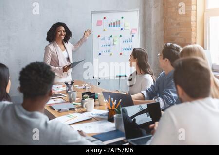 Professional marketologist making presentation during business meeting with colleagues Stock Photo
