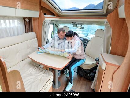 Couples in RV Camper looking at the local map for the trip. Family vacation travel, holiday trip in motorhome, Caravan car Vacation. Stock Photo