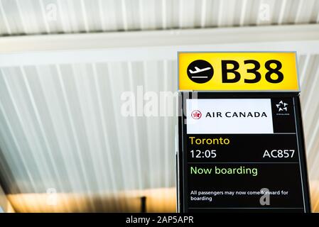 London, Heathrow Airport, Aug 2019: Gate B38 open for boarding. Flight announcement displayed on screen. Flying to Toronto with Air Canada Stock Photo