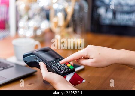 Cropped view of hand entering secure pin code on terminal to pay for the purchase with credit card. Cashless payment Stock Photo