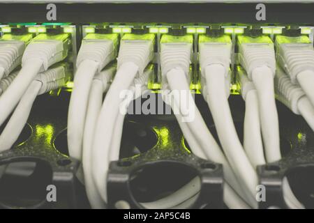 Internet switch with gigabit links is a close-up. The cables patch panel and network hub is in the server room data center. Many wires. Stock Photo