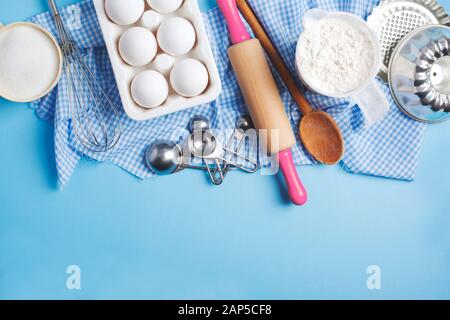 Baking background frame. Preparation for Easter baking. Ingredients and kitchen items for baking. Kitchen utensils, flour, eggs, sugar. Top view, copy Stock Photo