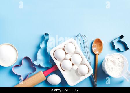 Baking background frame. Preparation for Easter baking. Ingredients and kitchen items for baking. Kitchen utensils, flour, eggs, sugar. Top view, copy Stock Photo