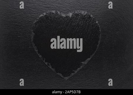 Black heart slate plate on black background Stock Photo