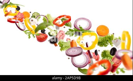 Fresh salad with flying vegetables ingredients isolated on whit Stock Photo