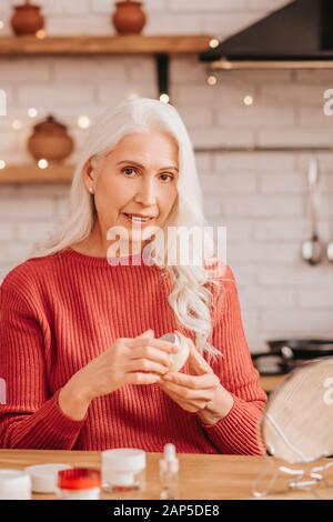 Grey-haired beautiful lady in red blouse looking contented Stock Photo