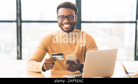 Black businessman making purchases using smart phone Stock Photo