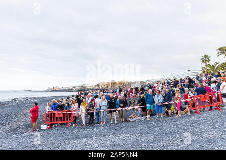 Crowds of people waiting for the arrival of the horses on the beach at the San Sebastian fiesta in La Caleta, Costa Adeje, Tenerife, Canary Islands. Stock Photo