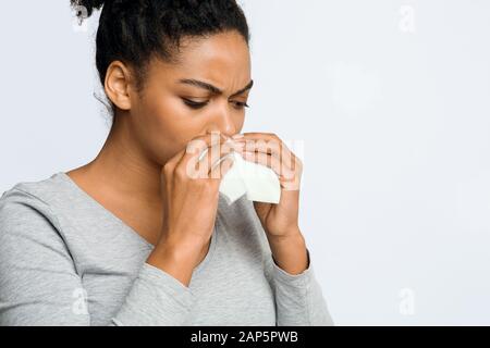 Woman wiping her nose with napkin, having flue Stock Photo