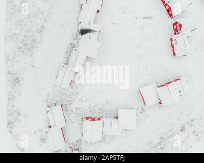 Scenic view of colorful wooden buildings top view. Fishing village and tourist town. Wooden red houses of fishing village in snowy covered in winter. Stock Photo