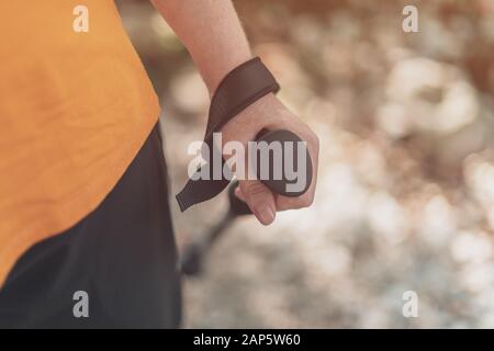 Trekking pole in female hiker hand, close up with selective focus Stock Photo