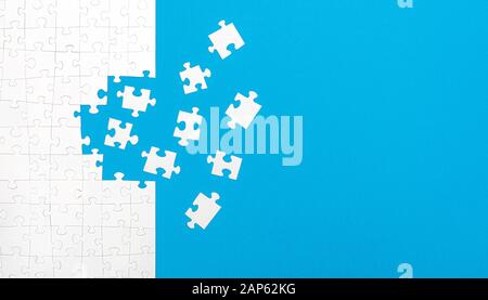 White jigsaw puzzle pieces on blue background copy space for your text. Business concept. Stock Photo