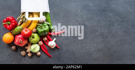 Healthy food selection: fruits, vegetable, seeds, superfood, leaf vegetable on gray concrete background in a shopping bag. Stock Photo