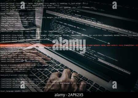 Hacker using laptop. Lots of digits on the computer screen. Stock Photo