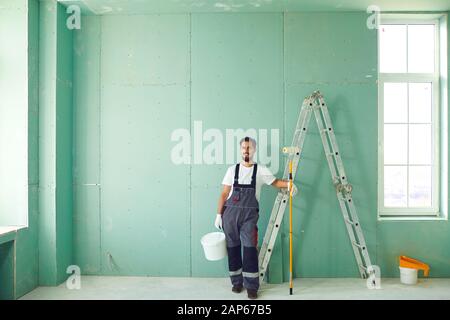 Bearded painter construction worker on a construction site. Stock Photo